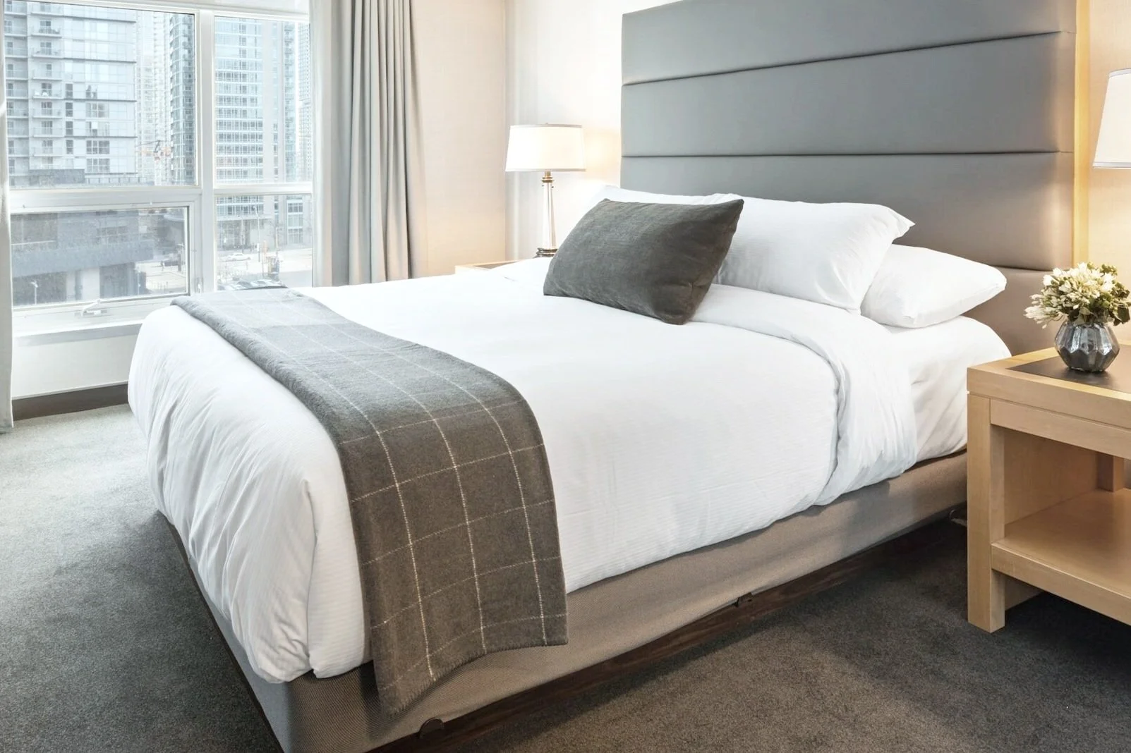 A luxury short-term rental bedroom with a downtown Indianapolis view